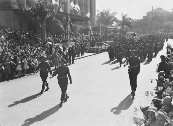 Members of the 2/9th march past Brisbane City Hall, August 1944