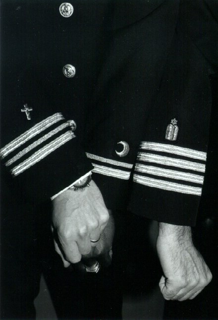 The insignia for Christian, Muslim, and Jewish chaplains are shown on the uniforms of three U.S. Navy chaplains.