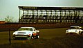 Aston Martin AM V8 - Derek Bell & David Preece leads Lotus Elan -52 - Max Payne & John Evans at the 1979 Silverstone 6 Hours (50248575131).jpg