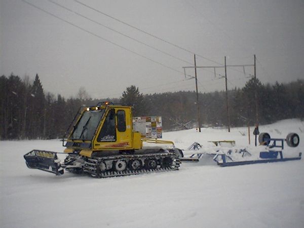 Bombardier BR180 snowcat pulling snowmobile trail groomer attachment