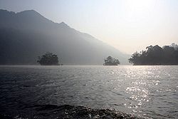 Um lago com ilhas e lados cobertos de árvores