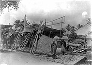 COLLECTIE TROPENMUSEUM Twee Balinezen poseren voor ingestorte huizen op Bali na de aardbeving van 1917 TMnr 10004142.jpg