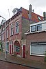 Winkelwoonhuis, rond 1900 gebouwd, en rond 1920 op de begane grond verbouwd, in een vrij drukke eclectische bouwtrant met wonderlijke bouwkundige en decoratieve details. Het pand is voor de gemeente Delft van algemeen belang vanwege de cultuurhistorische waarde. Het is van belang vanwege de bijzondere architectuur waarbij rond 1900, en bij een verbouwing rond 1920, veel fantasie aan de dag is gelegd om een decoratief gevelbeeld te bereiken.