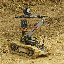 A small tracked robot in a sandy area