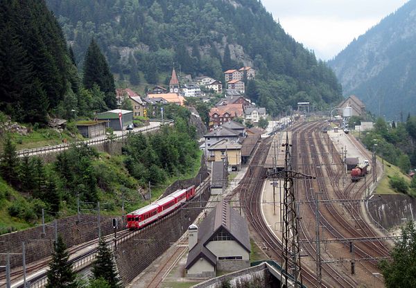 Göschenen station with MGB train at centre left and Swiss Federal Railways tracks at centre right.