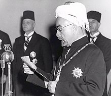 King Abdullah I on 25 May 1946 declaring independence, with Prime Minister Ibrahim Hashem in the background. King Abdullah I of Jordan declaring independence, 25 May 1946.jpg