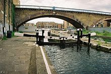 Original bridge at Limehouse on the London and Blackwall Railway. It now carries a branch of the DLR. The iron fencing being partially open was a feature of the line which was popular with passengers, as it gave a quieter ride than the reverberating brick walling of the nearby London and Greenwich Railway. This section of line was one of those to carry an iron roof when steam locomotives were first introduced. London Limehouse Blackwall.jpg