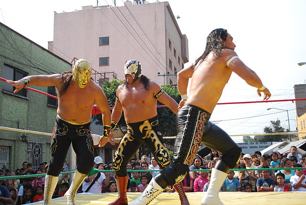 Último Guerrero with his son Taurus and Canelo Casas at an outdoor event.
