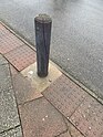 Wooden bollard painted grey, some paint is worn away