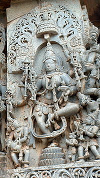 A picture of a sculpture of a eight-armed god dancing.