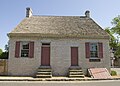 The house restored to its original look, with two doors at the front and without the dormers and the arch