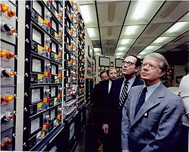 De Amerikaanse president Jimmy Carter en de gouverneur van Pennsylvania, Dick Thornberg, inspecteren het stralingscontrolepaneel in de controlekamer van de kerncentrale van Three Mile Island.  (1 april 1979)