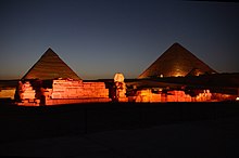 Un complexe de ruines, dont deux pyramides et la statue du Sphinx.