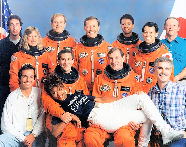 Alternate crew and support staff photo, featuring the seven crewmembers and Sharon McDougle, front center, among others.