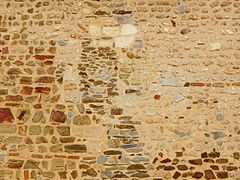 Fenêtre romane murée dans le mur de l'église.