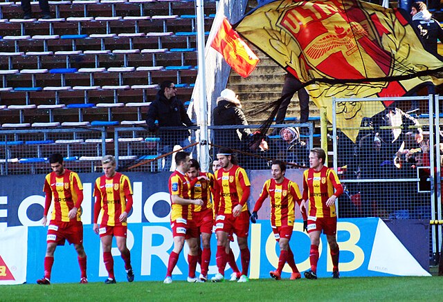 The Syrianska team, with supporters waving a flag behind them