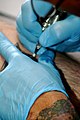 Realizando un tatuaje con guantes de látex