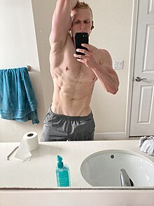 A shirtless man in a sexually suggestive pose taking a bathroom selfie Beepboopbopopo.jpg