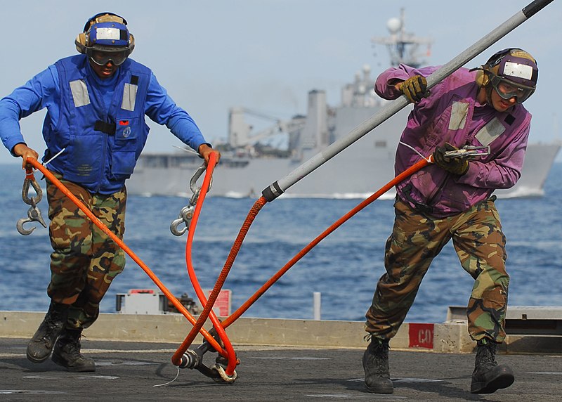 File:US Navy 091106-N-5538K-040 Sailors assigned to the amphibious transport dock ship USS Denver (LPD 9) remove a cargo pendant from fresh supplies during a vertical replenishment.jpg