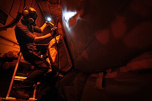 US Navy 120125-N-MD252-621 Aviation Structural Mechanic Airman David Southworth, assigned to Electronic Attack Squadron (VAQ) 134, paints an EA-6B .jpg