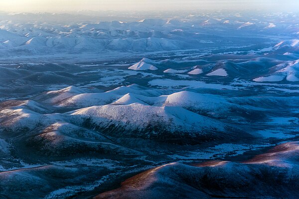 Landscape of the Verkhoyansk Range with smooth mountains and intermontane basins.