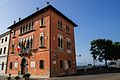 Palazzo Rosso di Giuseppe Segusini, sede del consiglio cittadino, e il balcone di Piazza Castello sul Piave