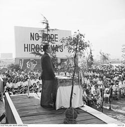 1948年広島平和祭。楠瀬常猪による演説。谷本清から始まったノー・モア・ヒロシマズ運動の看板が掲げられている。