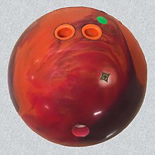A custom-drilled ball with a fingertip grip; finger holes are relatively far from the thumb hole, compared to balls having a conventional grip. 20190118C Reactive resin bowling ball fingertip grip pin up.jpg