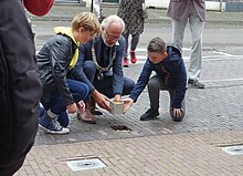 Woerden Victor Molkenboer legt met twee jongens de eerste Stolperstein op 30 september 2021, de dag waarop Fritz Rosenbaum in 1943 in Auschwitz overleed