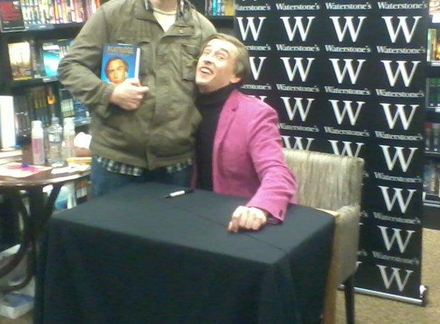 Coogan in character as Alan Partridge signing copies of the spoof autobiography I, Partridge: We Need to Talk About Alan