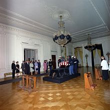 A U.S. armed forces honor guard places the casket bearing the body of President John F. Kennedy on a catafalque in the East Room of the White House at about 4:40 A.M. on November 23, 1963. Body of JFK being placed on catafalque in East Room.jpg