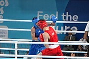 Deutsch: Boxen bei den Olympischen Jugendspielen 2018 Tag 12, 18. Oktober 2018 - Kampf um Bronze im Leichten Weltergewicht Jungen – Hassan Azim (Großbritannien, rot) schlägt Mohammed Boulaouja (Marokko, blau) RSC; Ringrichter ist Wulfren Olivares Peréz (Kolumbien). English: Boxing at the 2018 Summer Youth Olympics on 18 October 2018 – Bronze Medail Match Light Welterweight Boys - Hassan Azim (Great Britain, red) beats Mohammed Boulaouja (Morocco, blue) RSC; Referee is Wulfren Olivares Peréz (Columbia). Español: Boxeo en los Juegos Olímpicos Juveniles de Verano de 2018 en 18 de octubre de 2018 - Medalla de bronce de los hombres ligeros de peso welter: Hassan Azim (Gran Bretaña, rojo) vence a Mohammed Boulaouja (Marruecos, azul) RSC; El árbitro es Wulfren Olivares Peréz (Colombia).