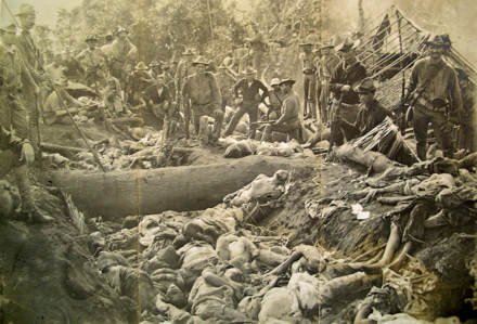U.S. soldiers pose with Moro dead after the Moro Crater massacre in 1906.