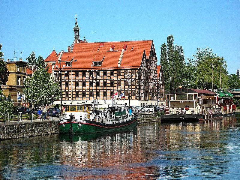 File:Bydgoszcz Spichrze na tle statku czerwiec.jpg