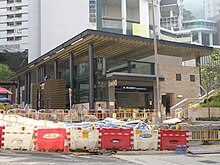 Construction site of Kennedy Town station of the MTR, on Smithfield in 2014. Block D of Kwun Lung Lau is visible in the background. Entrance and exit C of Kennedy Town Station finished construction (October 2014).JPG
