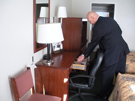 A Gideon member placing a Bible in a motel room Gideon member distributing scripture in motel room.jpg