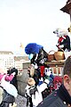 File:Gugge at Mittlere Brücke during Cortège of Basler Fasnacht throwing Räpple (confetti) into audience jacket.jpg