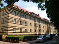 Four multi-family houses in a residential complex with front gardens and enclosure walls