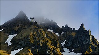 Vue de la gare téléphérique (dans la brume) et du rocher de l'Ours (à droite).