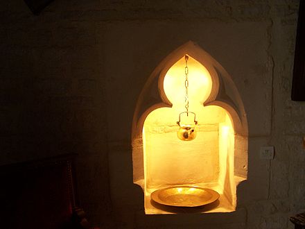 A 14th-century lavabo as a niche recessed into the side wall of a sanctuary in Amblie, Normandy