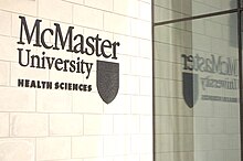 Signage at the Michael DeGroote Centre for Learning and Discovery featuring the university's arms. McMaster University Health Sciences entrance.jpg