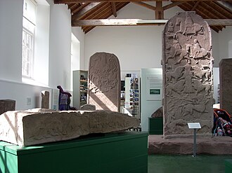 View of the Meigle museum including the backs of Meigle 4 at left and Meigle 2 at right, with one side of Meigle 26 in the foreground. Meigle Museum.jpg