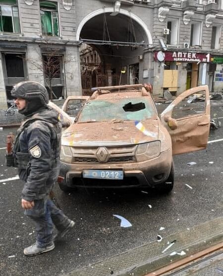 Policeman by a destroyed Renault Duster police car during the Battle of Kharkiv at the Russian invasion of Ukraine