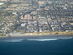 Aerial view of part of old town Encinitas showing Moonlight Beach on the left. Parallel with the shore is Historic Coast Highway 101; also parallel and further inland is Interstate 5.