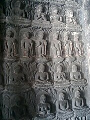 Multiple depictions of Buddha on a wall at Ajanta Caves