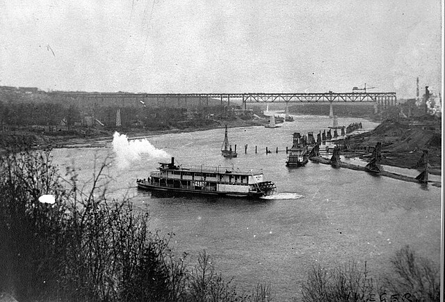 The North Saskatchewan in Edmonton circa 1913. Steamboats in the foreground, construction of the High Level Bridge in the background, and mid-river pi