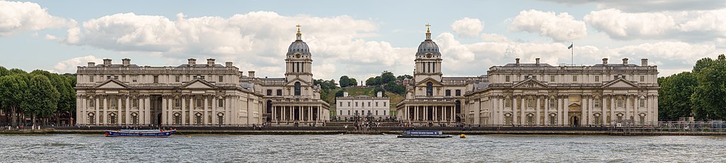 Panoramic photograph of the two buildings of the Old Royal Naval College, with the River Thames in the foreground