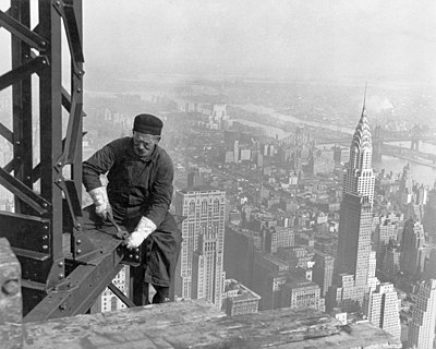 A construction worker atop the Empire State Building as it was being built in 1930; to the right is the Chrysler Building.