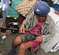 Roadside_Bulakeño_shoemaker_at_work_in_shoe_repair_shop_01