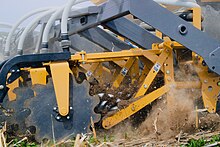 The SoilWarrior machine is used for strip-tillage. Instead of using a shank/knife, the machine uses a cog to till the soil into strips. Strip-till demonstration through SoilWarrior.jpg